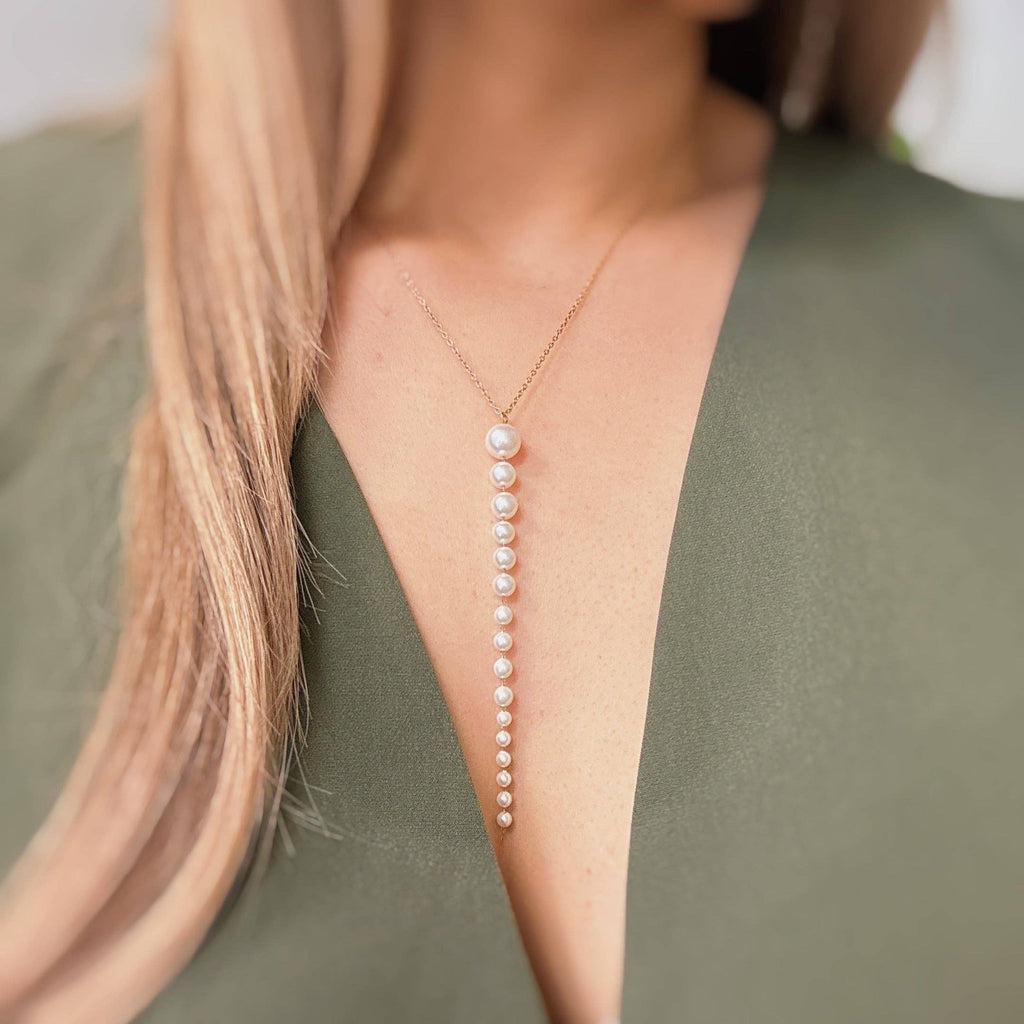 Gradiant long pearl necklace worn by a person