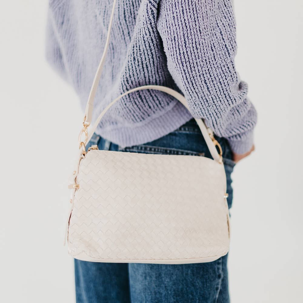 Person holding a white woven handbag 