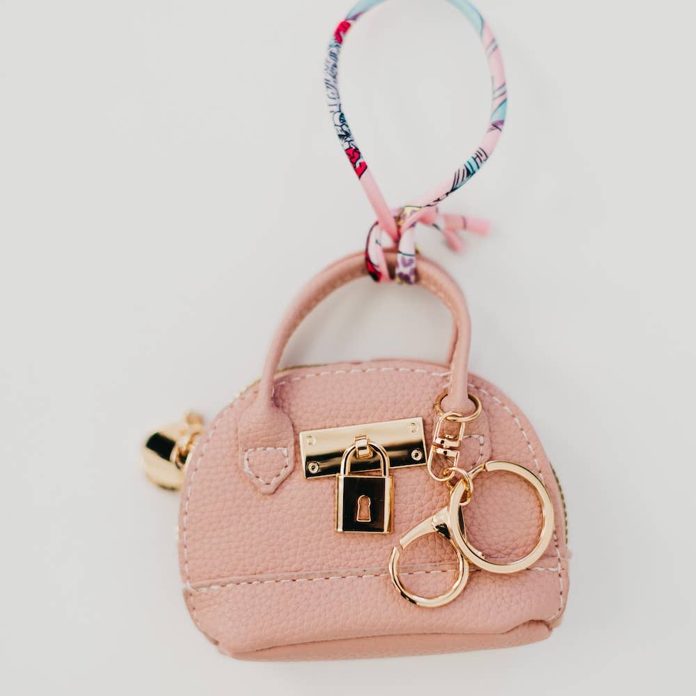 Pink purse-shaped keychain with gold lock and key design 