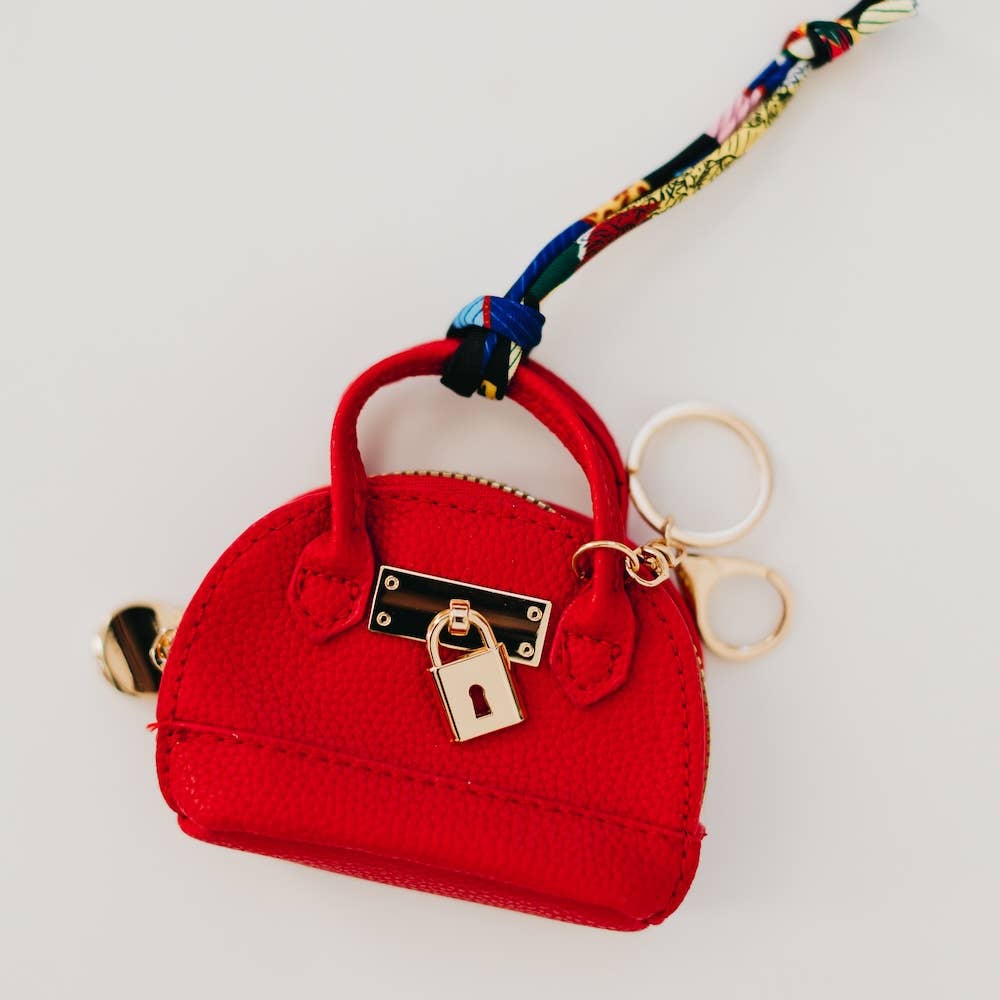 Red purse-shaped keychain with gold lock and key design 