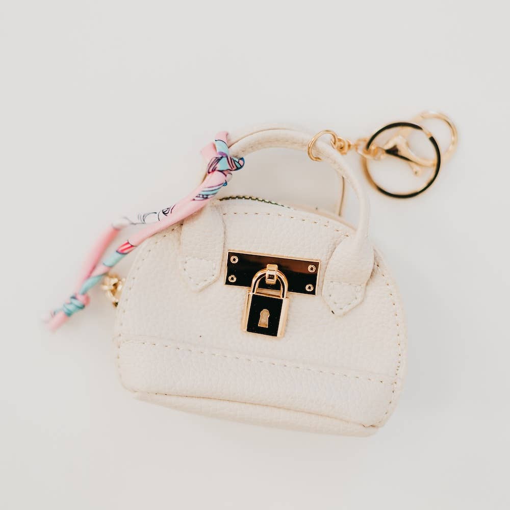 White purse-shaped keychain with gold lock and key design 