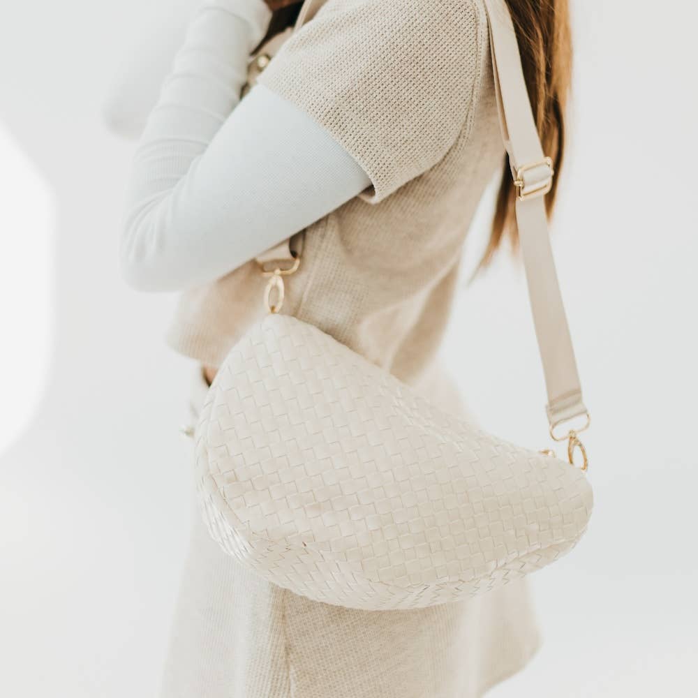Whitewoven handbag worn by a person on a white background