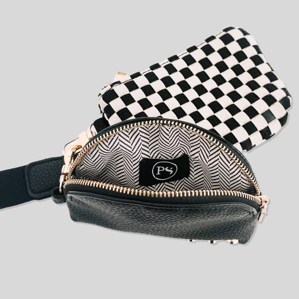 The inside of a black and white wristlet pouch with a curved design and gold zipper.