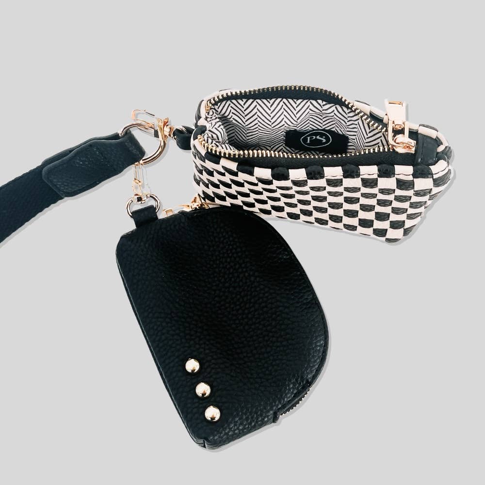 The inside of a black and white wristlet pouch with a curved design and gold zipper.